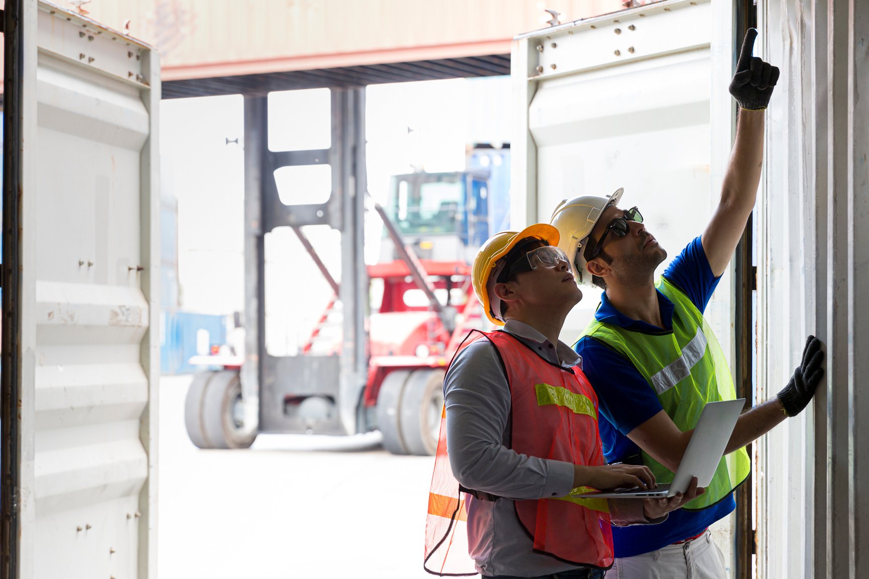 Foreman inspecting the cargo container. Foreman and staff are opening containers to check stock.